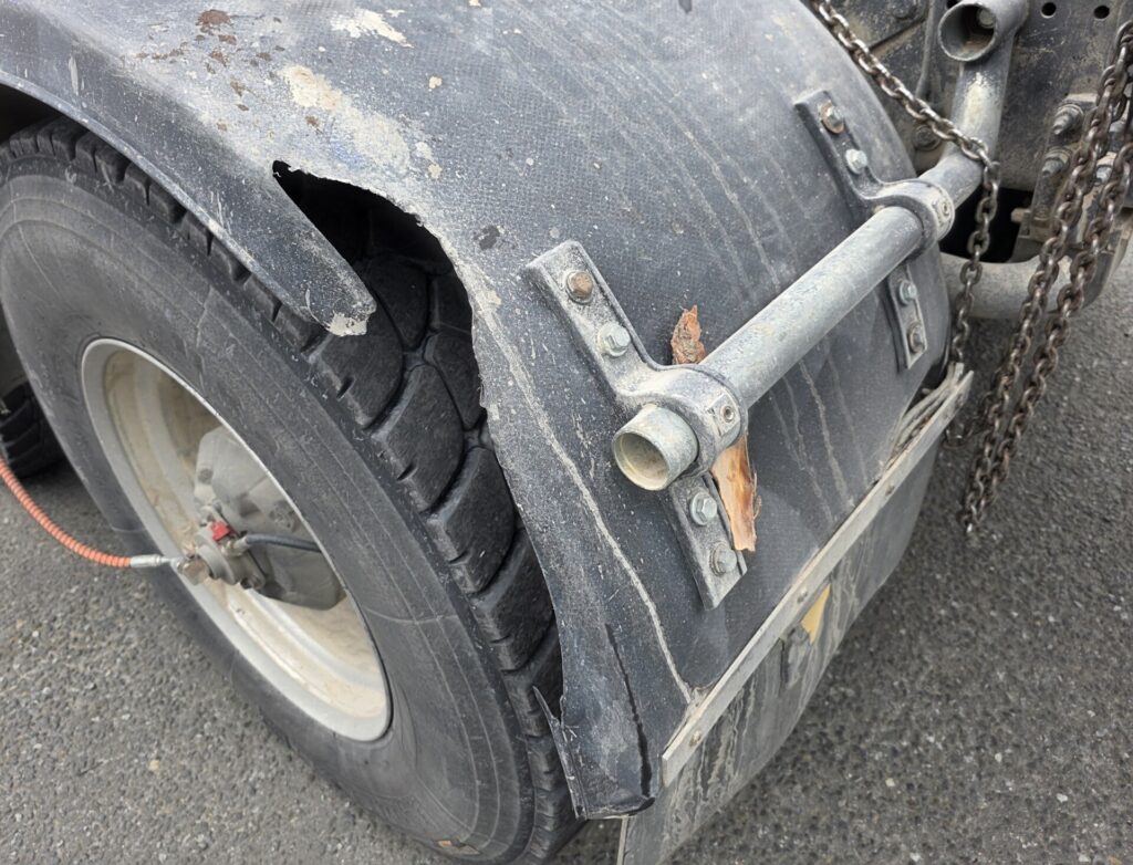 Other brand thermoformed plastic mudguard with large structural tear and section loss in service