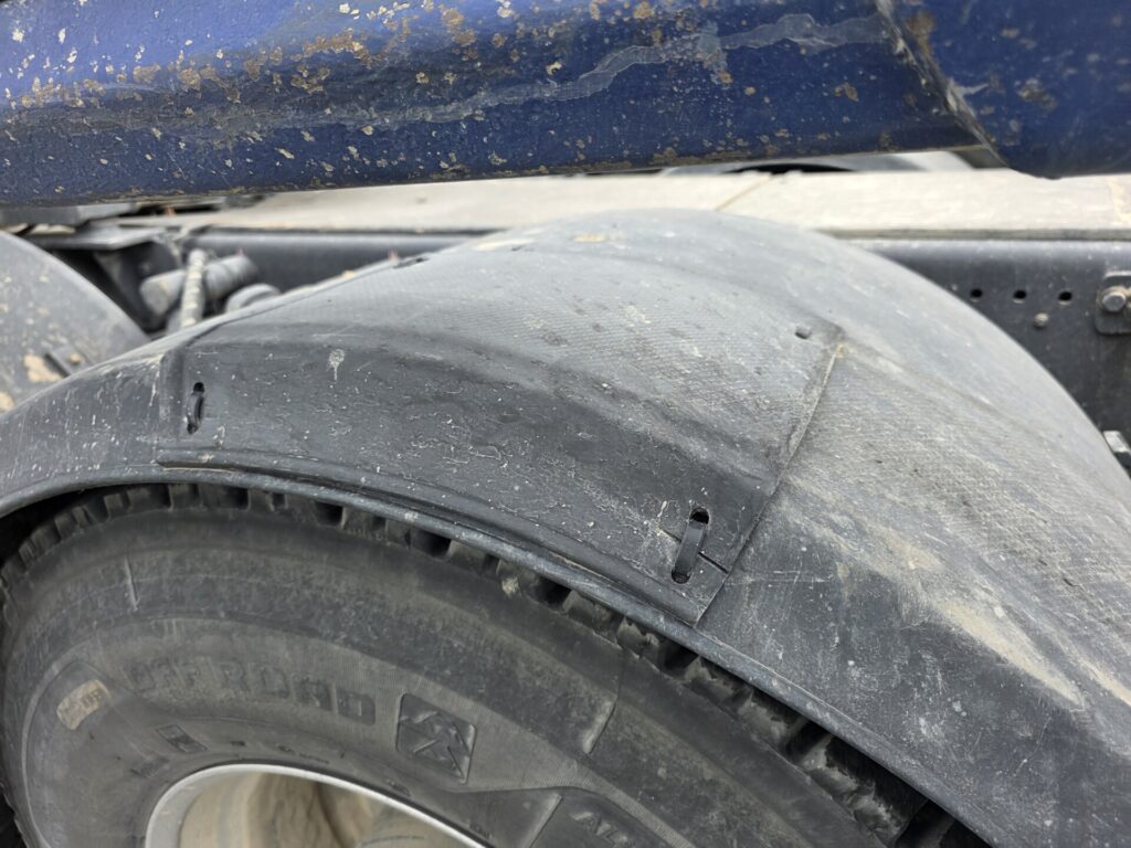 Other brand thermoformed plastic mudguard showing patch repair, 